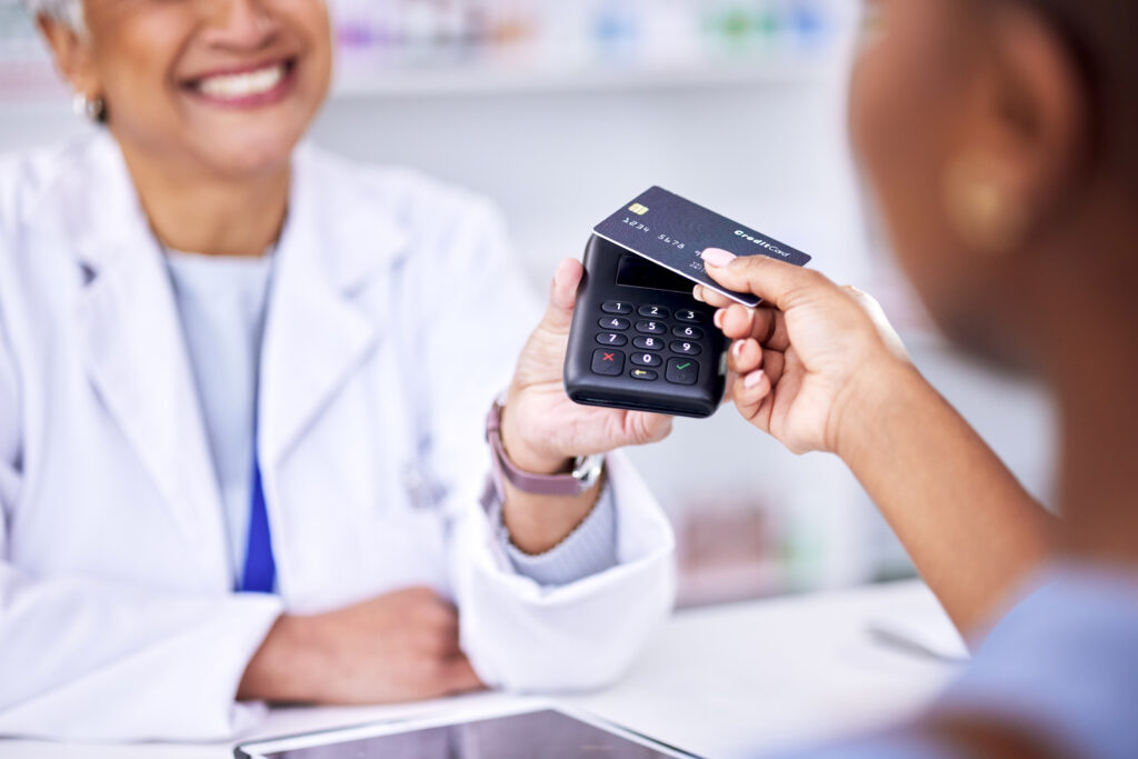 the best ways to create a profitable pharmacy through human connection, client paying female pharmacist with credit card tap
